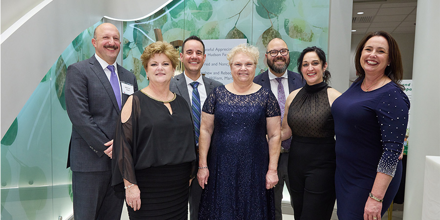 The GBMC oncology team stands in front of the bell