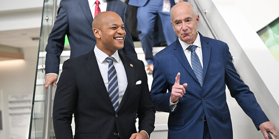 Outgoing GBMC President and CEO John B. Chessare walking down the stairs with Maryland Governor Wes Moore