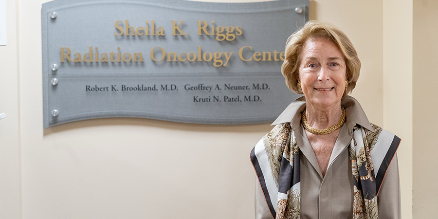Sheila Riggs, a donor, in front of a plaque bearing her name