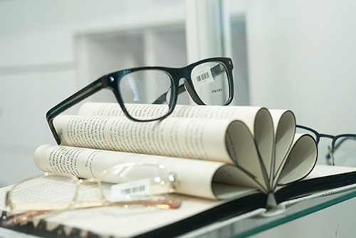 Eyeglass frames displayed on open books