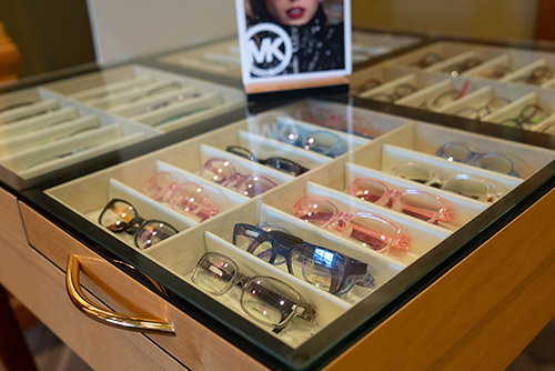 Display drawer with many pairs of eyeglasses.