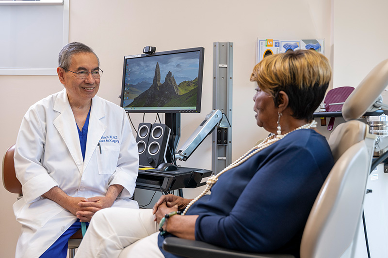 A GBMC head and neck surgeon listens to a patient during an office visit