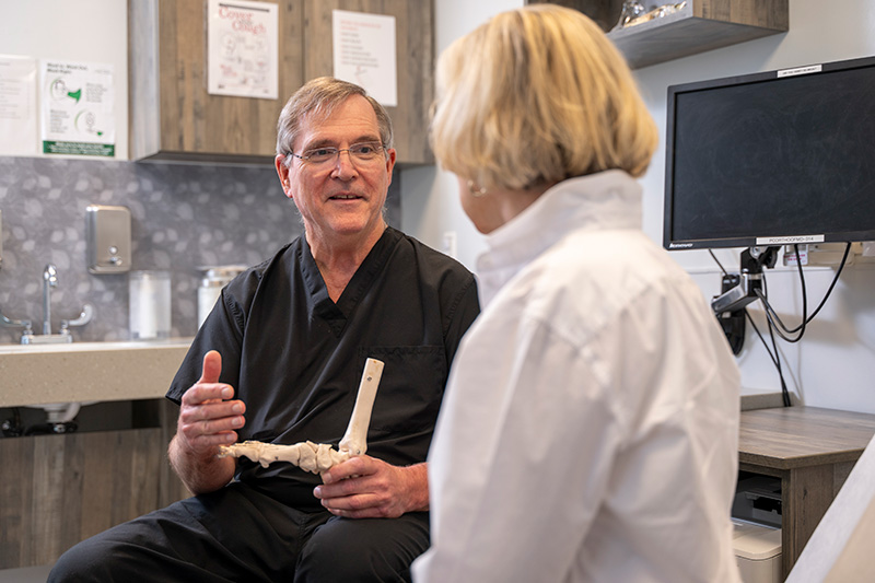 James Johnston, MD, explaining a joint model to a patient