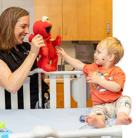 Doctor playing with child in hospital bed